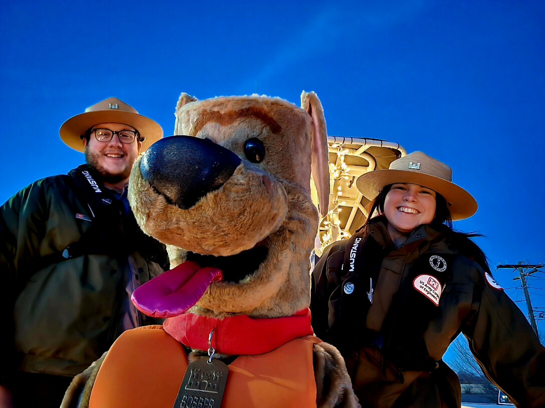 John Martin Reservoir park rangers Trevor Schuller (left) and Holly Garnett (right) take a selfie with Bobber the Water Safety Dog at the Las Animas, Colorado, Parade of Lights, Dec. 16, 2023.
