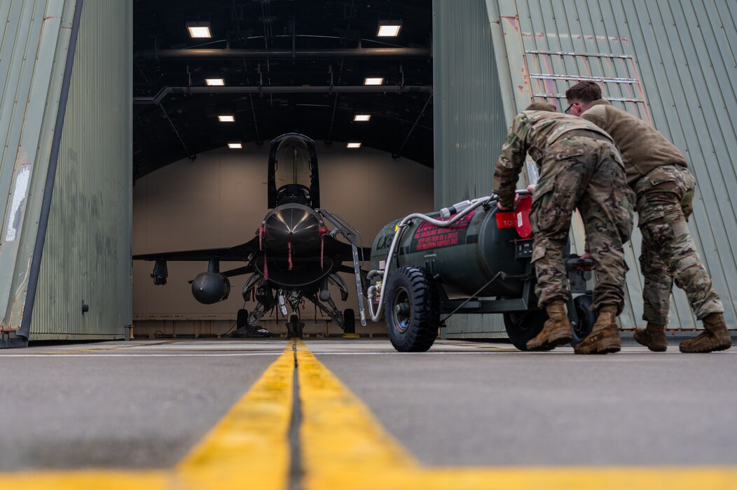 U.S. Air Force Senior Airman Francisco Ramirez, 36th Fighter Generation Squadron crew chief, and Senior Airman Jacob Smith, 13th FGS assistant dedicated crew chief, retrieve a liquid oxygen cart for servicing during the Ninja Mustang training event at Misawa Air Base, Japan, March 6, 2024. The airframe, powerplant and general Airmen that participated in this event maintained the F-16 Fighting Falcons from the 51st FW with help from the 13th FS, who housed the aircraft during the event. (U.S. Air Force photo by Airman 1st Class Chase Verzaal)