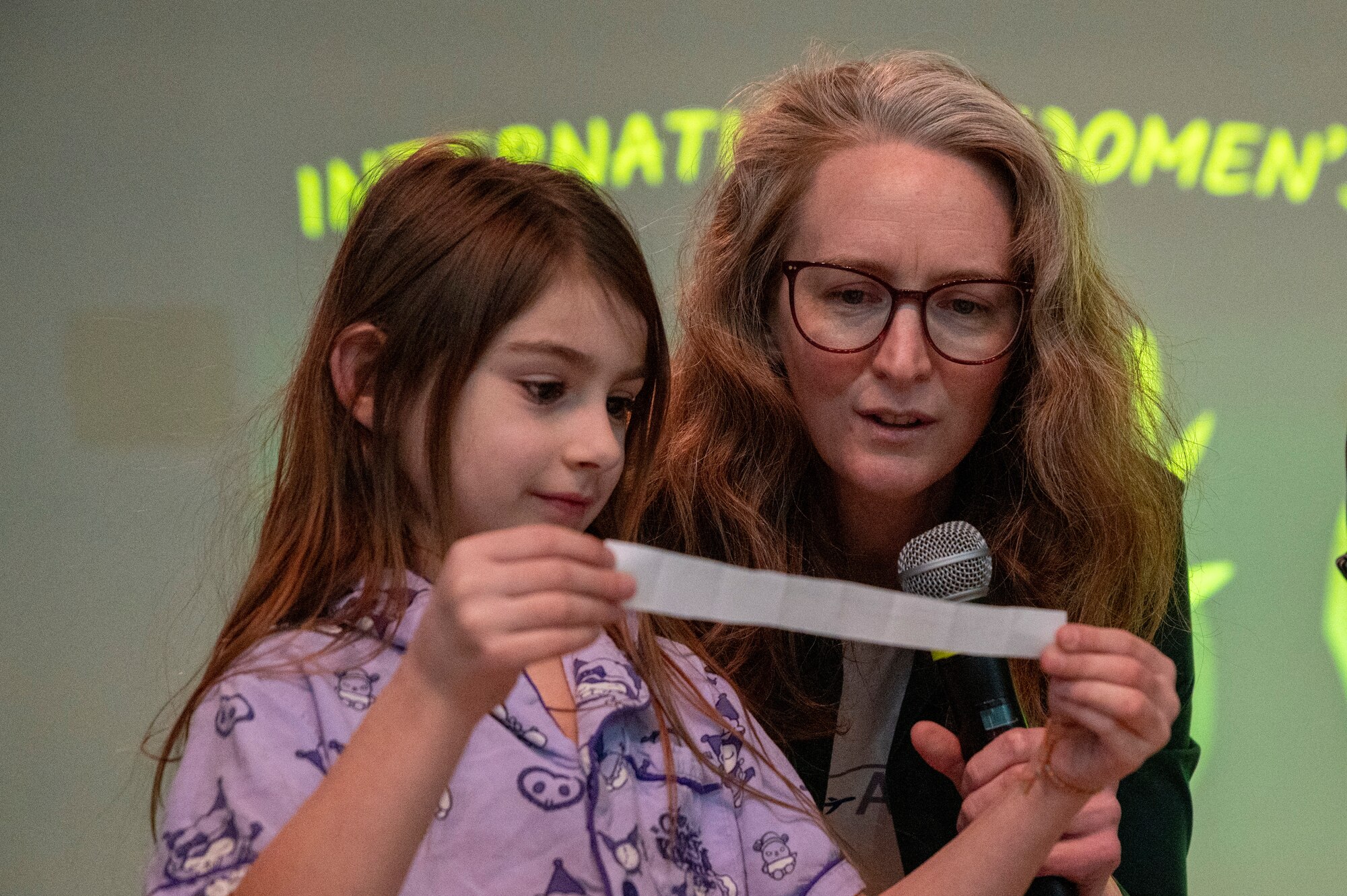 K. Emma Knowland, NASA associate research scientist, helps an Osan Elementary School student read a NASA trivia question during a Women’s History Month panel at Osan Air Base, Republic of Korea, March 8, 2024.