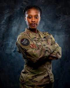 U.S. Space Force Spc. 3 Shayla Wiley, 74th Intelligence, Surveillance and Reconnaissance poses in front of a blue background.