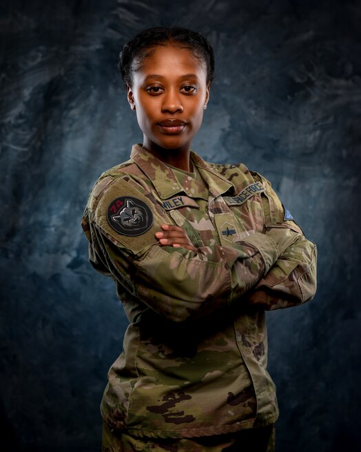  U.S. Space Force Spc. 3 Shayla Wiley, 74th Intelligence, Surveillance and Reconnaissance poses in front of a blue background.