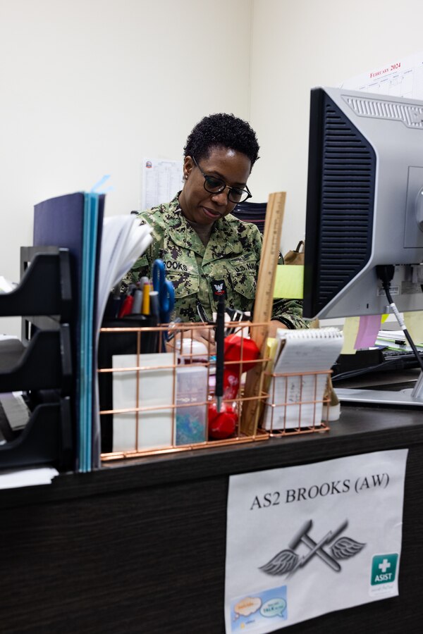 U.S. Navy Aviation Support Equipment Technician Second Class Patrice Brooks, a native of Jamaica, with Aircraft Intermediate Maintenance Department (AIMD) Iwakuni, signs papers in her office at MCAS Iwakuni, Japan, Feb. 16, 2024. As the command career counselor for AIMD Iwakuni and president of the Coalition of Sailors Against Destructive Decisions, Brooks holds a responsibility to ensure all Sailors under her guidance are well prepared to advance their careers and be valuable contributors to the community. (U.S. Marine Corps photo by Cpl. Isaac Orozco)