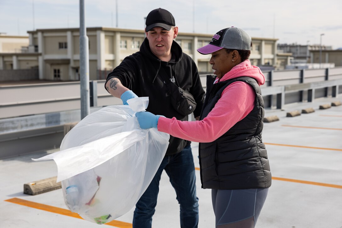 U.S. Navy Aviation Electronics Technician Second Class Alexander Gomez (left), a California native, and Aviation Support Equipment Technician Second Class Patrice Brooks (right), a native of Jamaica, with Aircraft Intermediate Maintenance Department (AIMD) Iwakuni, collect trash during a volunteer event at MCAS Iwakuni, Japan, Feb. 25, 2024. As the command career counselor for AIMD Iwakuni and president of the Coalition of Sailors Against Destructive Decisions, Brooks holds a responsibility to ensure all Sailors under her guidance are well prepared to advance their careers and be valuable contributors to the community. (U.S. Marine Corps photo by Cpl. Isaac Orozco)