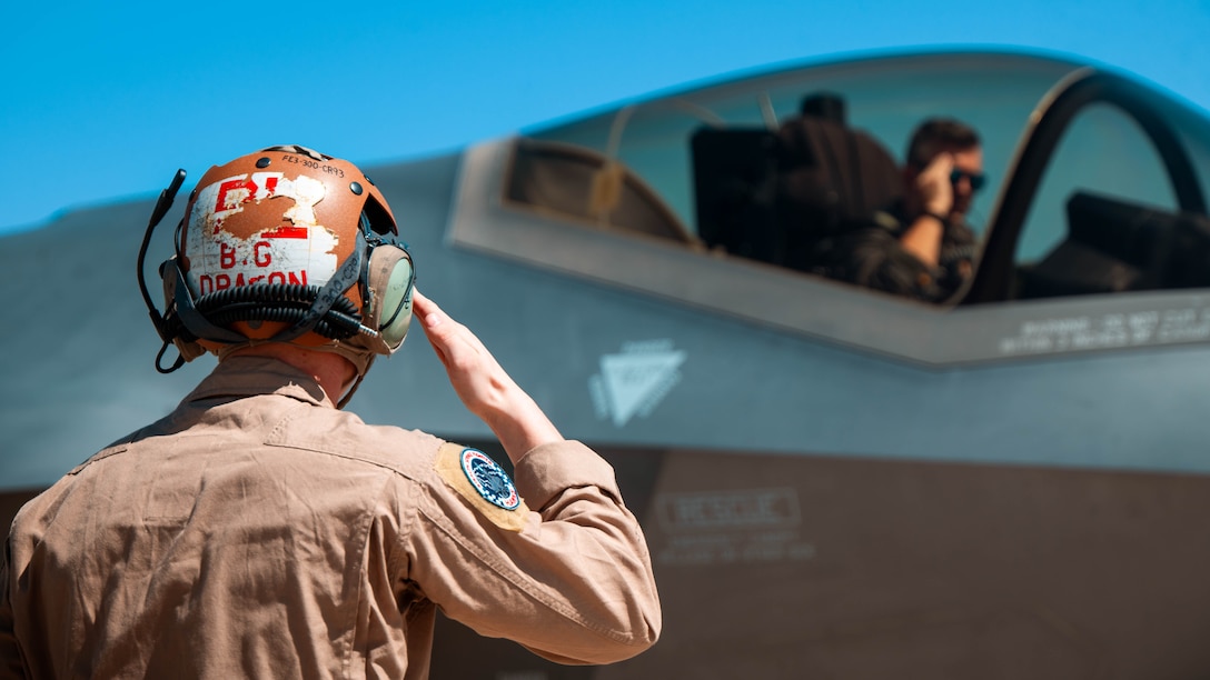 U.S. Marine Corps Cpl. Thomas Hawley, VMFA-533 powerline plane captain, salutes an F-35A Lightning II pilot, March 13, 2024, at Luke Air Force Base, Arizona. The collaboration between Luke AFB and Yuma serves to strengthen Agile Combat Employment (ACE), a strategic approach designed to ensure airpower survivability and resilience in contested environments.