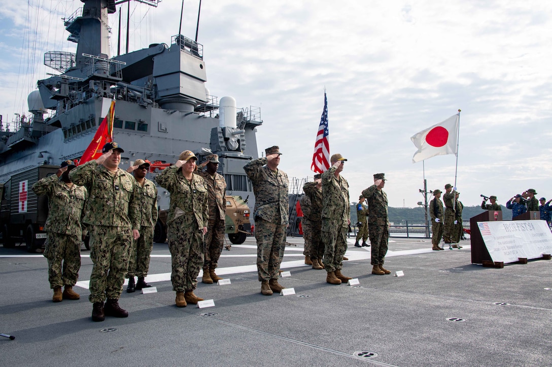 OKINAWA, Japan (Mar. 17, 2024) From left to right: Commanding Officer of the forward-deployed amphibious assault carrier, USS America (LHA 6), Capt. Manny Pardo; Commodore of Amphibious Squadron 11, Capt. Kelly Fletcher; Commanding Officer, 31st Marine Expeditionary Unit, Col. Matthew Danner; Commander, Task Force 76/3, Rear Adm. Christopher Stone; and Commanding General of 3rd Marine Expeditionary Brigade, Brig. Gen. Trevor Hall salute during the closing ceremony of Exercise Iron Fist, aboard the Ōsumi-class tank landing ship JS Kunisaki (LST-4003), in Okinawa, Japan, Mar. 17. Iron Fist is an annual bilateral exercise designed to increase interoperability and strengthen the relationships between the U.S. Marine Corps, the U.S. Navy, the Japan Ground Self-Defense Force, and the Japan Maritime Self-Defense Force. (U.S. Navy photo by Mass Communication Specialist 2nd Class Cole Pursley)