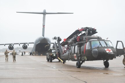 Soldiers and Airmen with the 157th Air Refueling Wing, 238th Medevac Company and the 167th Airlift Wing load two Black Hawk helicopters for Exercise Granite Falco into a C-17 Globemaster III March 15, 2024, at Pease Air National Guard Base, New Hampshire. During the four-week exercise, the teams will conduct simulated flying missions in the Black Hawks and provide basic medical training to Cabo Verdean military personnel and first responders.