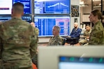 Man in uniform listens to a briefing while sitting down