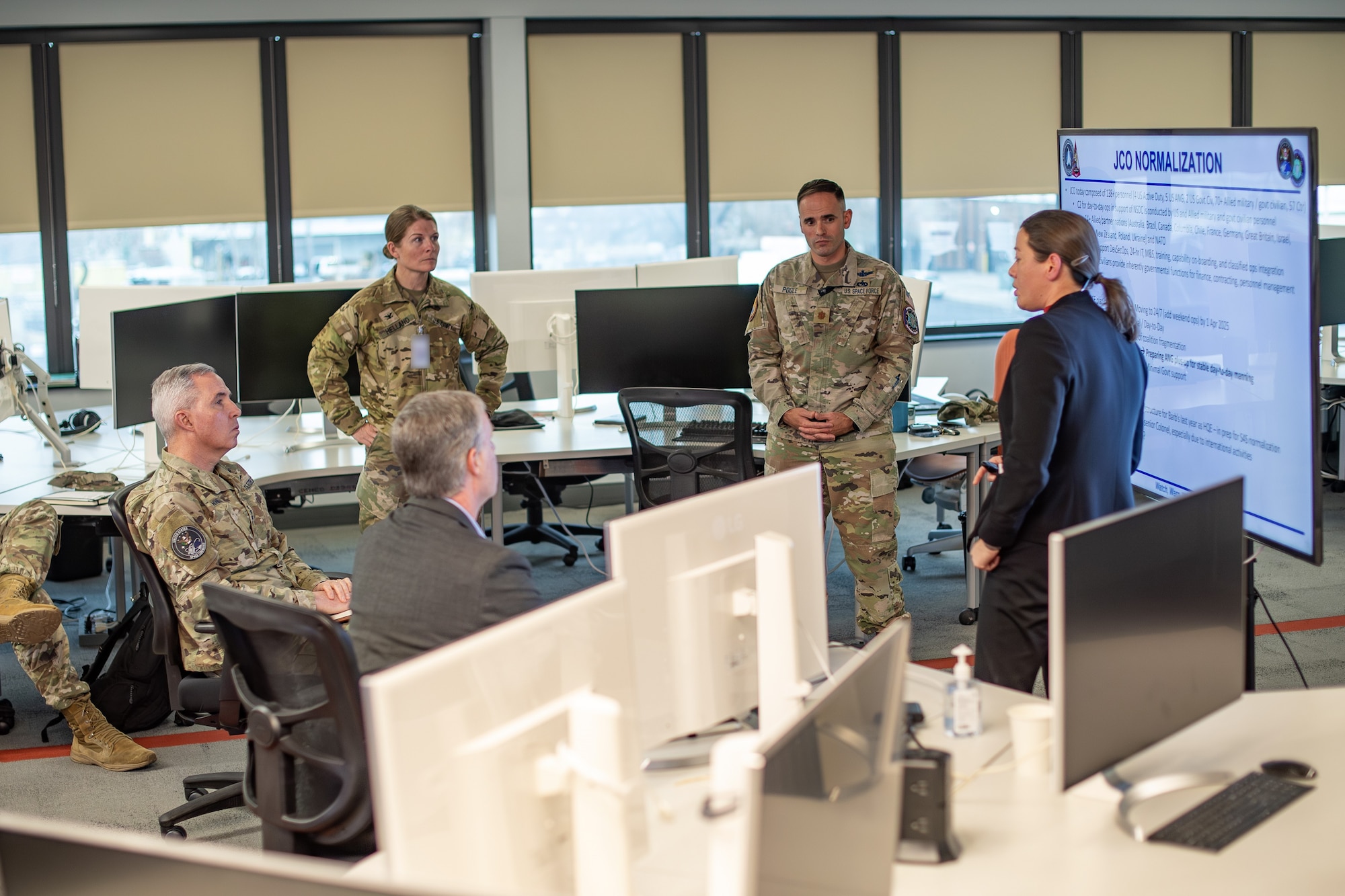 Group of people sit in a circle and listen to a briefing