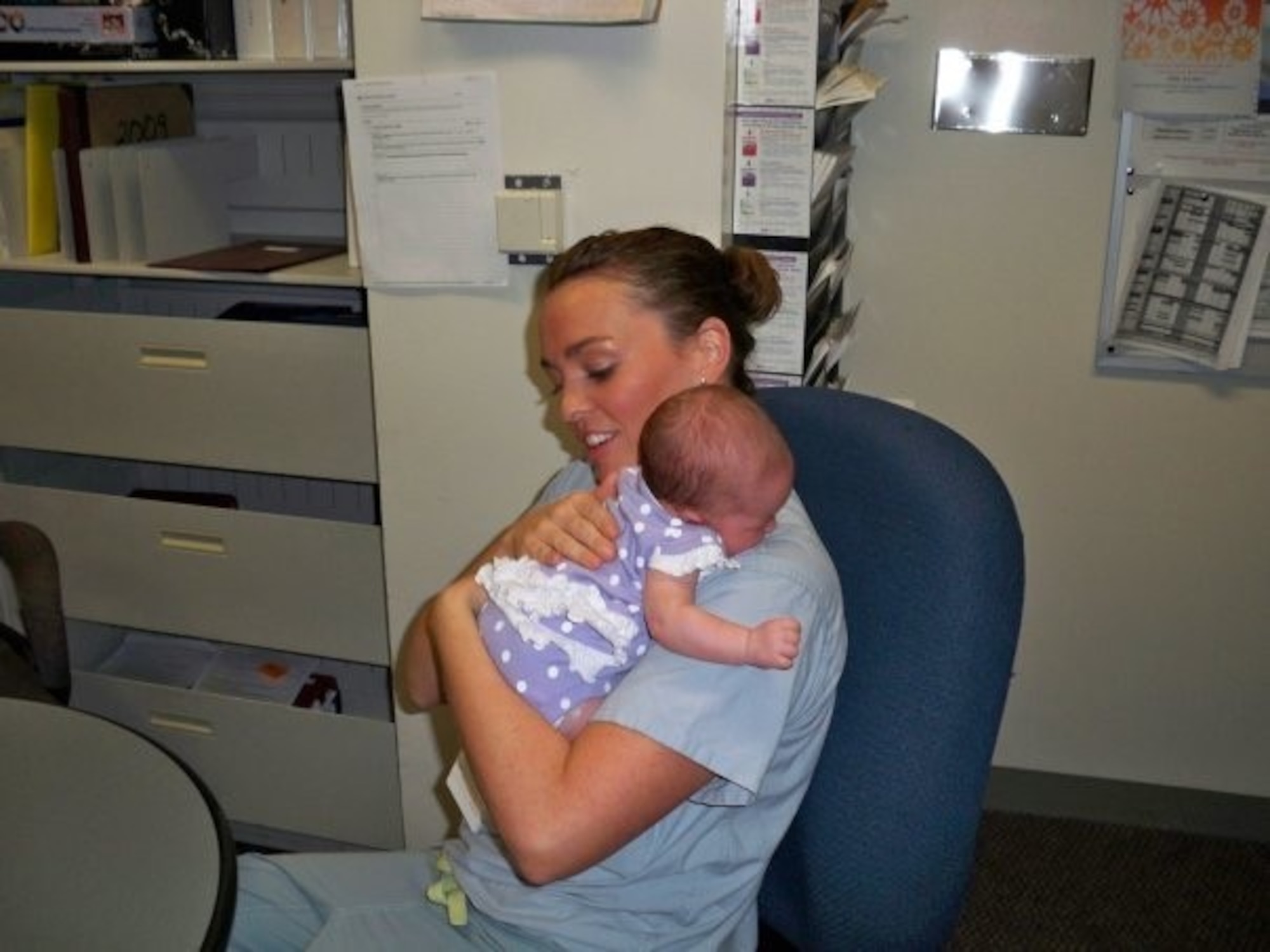 U.S. Air Force Lt. Col. Danielle Merritt, currently serving as the 9th Operational Medical Readiness Squadron commander, holds Charlotte Nowlin, a baby she delivered when she was a lieutenant at Wilford Hall Birthing Center, Lackland Air Force Base, Texas, 2009.