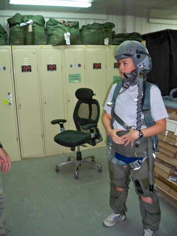 U.S. Air Force Lt. Col. Danielle Merritt, currently serving as the 9th Operational Medical Readiness Squadron commander, tries on a fighter pilot jumpsuit as she is instructed on what fighter pilots experience during flight while deployed to Iraq, 2009.