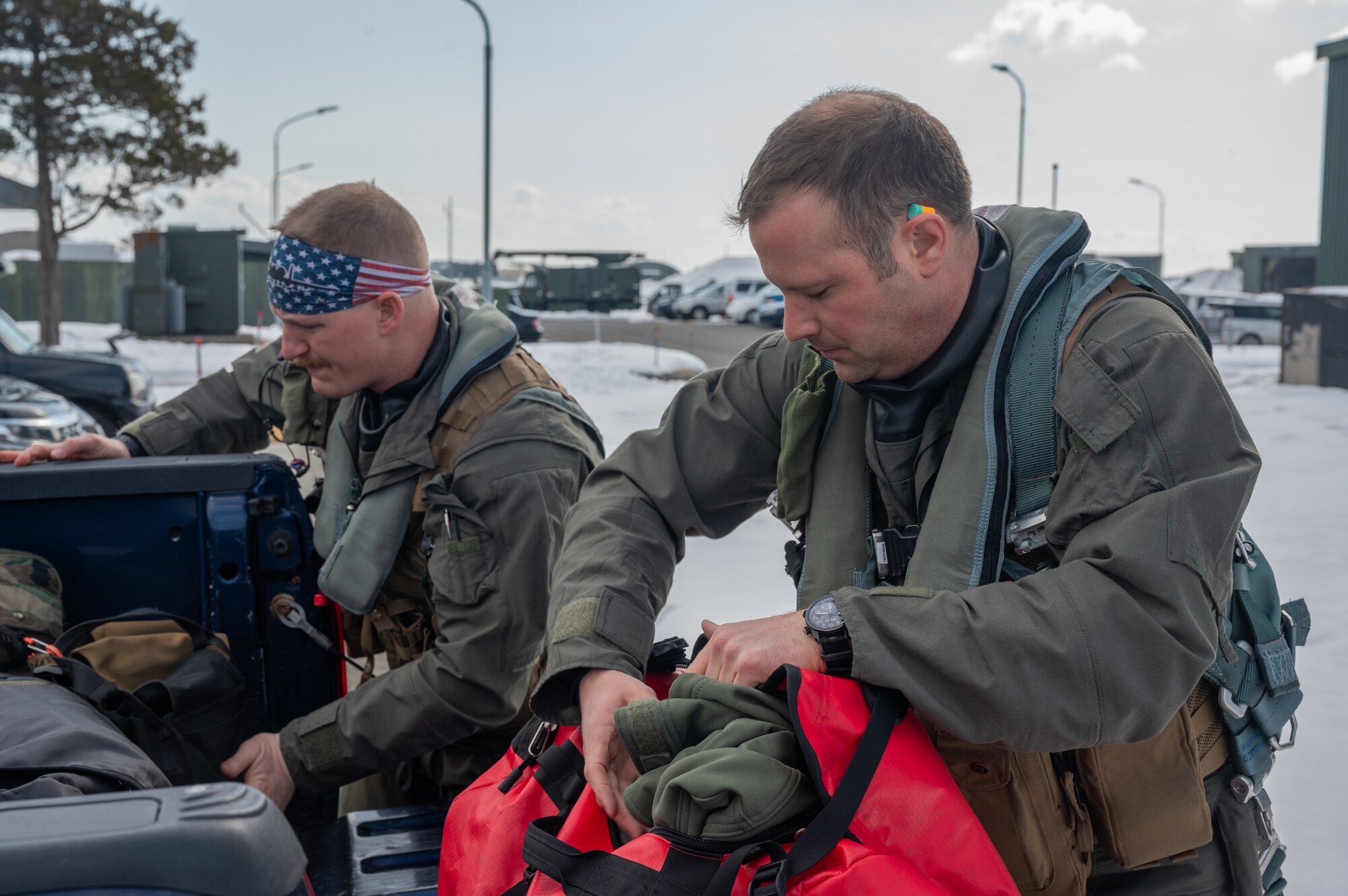U.S. Air Force Capt. Jacob Stafford, 25th Fighter Squadron A-10C Thunderbolt II pilot, left, and Lt. Col. Justin Ledvina, 25th FS director of operations, pack bags before a flight during the Ninja Mustang training event at Misawa Air Base, Japan, March 7, 2024. The 25th FS organized the training event to develop more lethal Airmen within the 51st Fighter Wing, who can perform their job and execute the mission in an unfamiliar location with limited resources. Ninja Mustang is a training event within the Ninja Draggin series, where 51st FW Airmen relocate to collaborate with units across the Pacific. This initiative enhances the lethality and coordination of units within the pacific theater. (U.S. Air Force photo by Airman 1st Class Chase Verzaal)