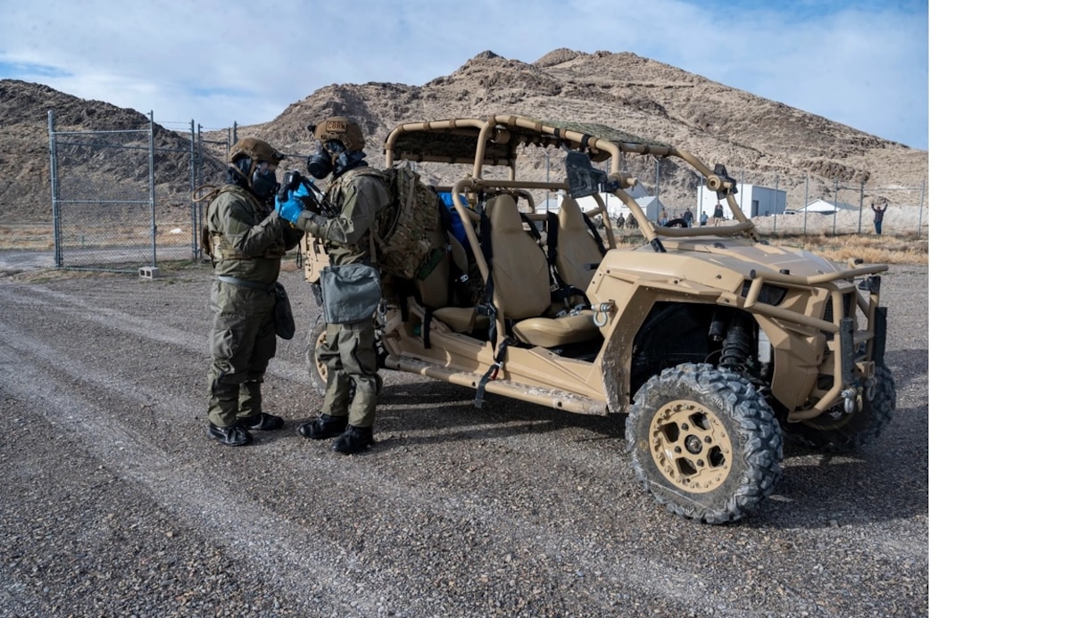 U.S. Air Force Staff Sgt. Tyler Lee, 209th Special Operations Civil Engineering Squadron equipment NCO, left, and Tech. Sgt. Chadwick Moore, 209th SOCES NCO in charge, right, don mission-oriented protective posture gear for a mass casualty scenario during Exercise Emerald Warrior 24, at Dugway Proving Ground, Utah, March 6, 2024. Air Force Special Operations Command continuously exercises the ability to deploy to distributed locations, generate airpower for joint forces, provide logistical support, and adapt to operations quickly. (U.S. Air Force photo by Staff Sgt. Aaron Irvin)