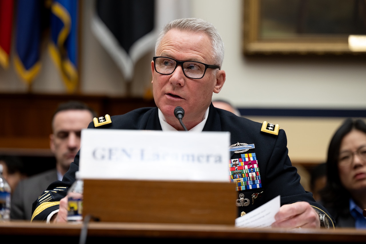 A man in a military uniform speaks into a microphone.