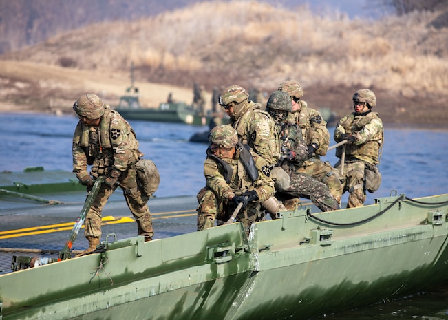 U.S. Army Engineer Soldiers from the 814th Engineer Company, pull on a rope in order to connect bridging equipment during a wet gap crossing training for Freedom Shield 24, March 14, 2024, in South Korea. FS24, provides a rigorous environment to enhance readiness, interoperability, and response capabilities in realistic scenarios. (Texas Army National Guard photo by Spc. Joe Cantu, 100th Mobile Public Affairs Detachment)
