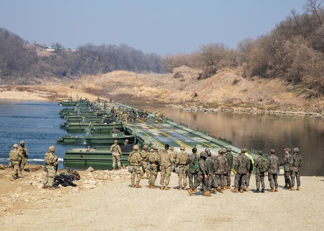Key leaders from the U.S. Army, 814th Engineer Batallion, along with key leaders from the Republic of Korea Army, 5th Engineer Battalion, observe as soldiers finish connecting bridging equipment during a wet gap crossing training for Freedom Shield 24, March 14, 2024, in South Korea. In support of the Armistice Agreement, FS24, underscores the enduring military partnership between the ROK and the U.S. It reinforces the role of the alliance as the linchpin for regional peace and security, reaffirming the unwavering commitment of the U.S. to help defend the Republic of Korea. (U.S. Army National Guard photo by Spc. Joe Cantu, 100th Mobile Public Affairs Detachment)
