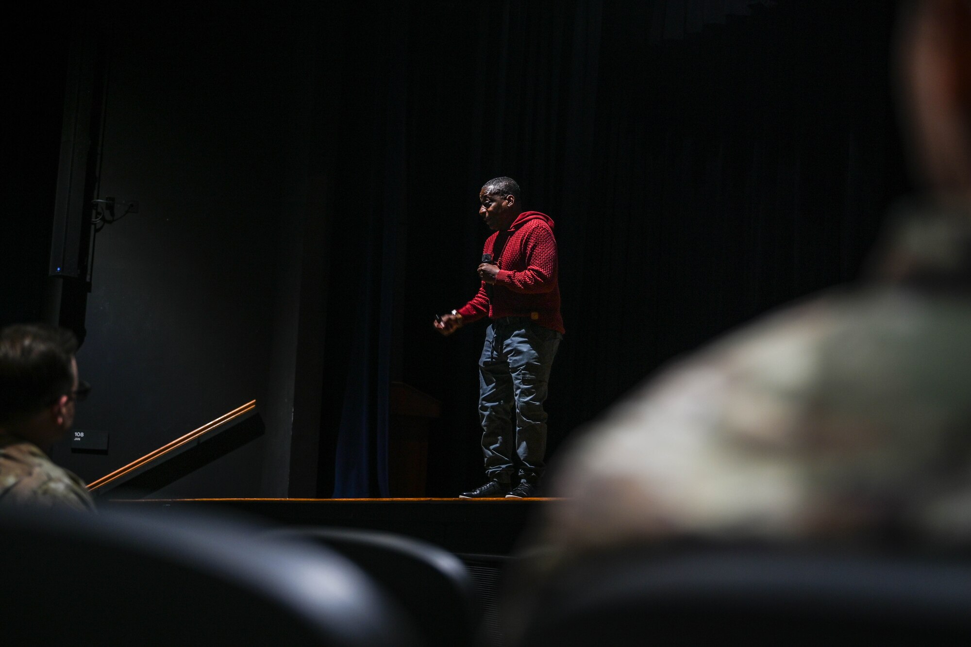 A man speaks on a stage.
