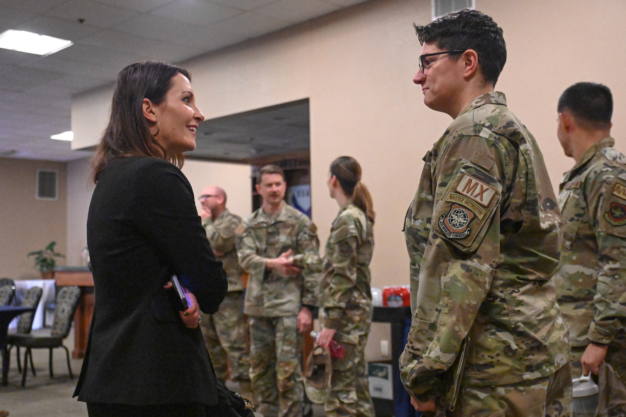 A woman speaks to an Airman.