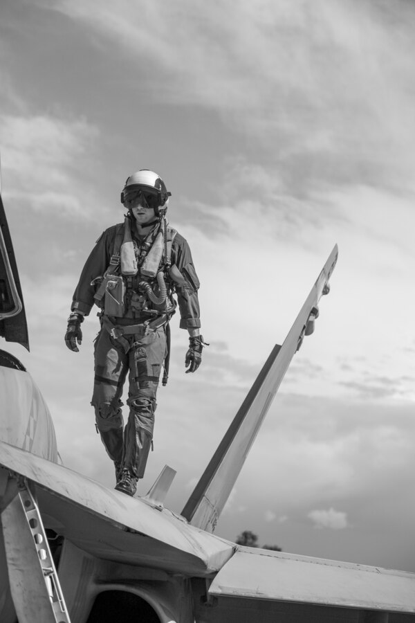 U.S. Marine Corps Capt. Michael Logrande, a student weapons systems officer with Marine Fighter Attack Squadron (VMFA) 323, Marine Aircraft Group 11, 3rd Marine Aircraft Wing, conducts preflight checks on an F/A-18D Hornet assigned to VMFA-323 before a section engaged maneuvering flight at Marine Corps Air Station Miramar, California, March 18, 2024. LoGrande conducted his final student flight with VMFA-323's Fleet Readiness Detachment before graduating on March 22, 2024, as the Marine Corps last WSO. (U.S. Marine Corps photo by Sgt. Sean Potter) (This image was manipulated using desaturation techniques)