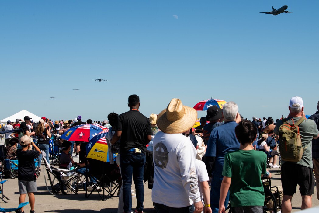 crowd watching cargo airplanes fly by