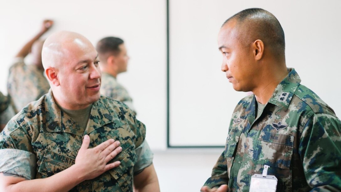 U.S. Marine Corps Master Gunnery Sgt. Byron G. Pimentel, operations chief, G-6/G-39, U.S. Marine Corps Forces, Pacific, speaks with Commander Weerakamon Suanchan, operations planner, Royal Thai Marine Corps, for his continued support to MARFORPAC throughout our various engagements during a subject matter expert exchange between Pacific Marines and Royal Thai military cyber personnel in Sattahip, Thailand, Feb. 19-23, 2024. The exchange represents a crucial step forward in advancing defensive cyber operations and fostering stronger partnerships with our Allies in the Indo-Pacific region. (Courtesy photo by Public Affairs personnel of the Royal Thai Marine Corps Headquarters base)