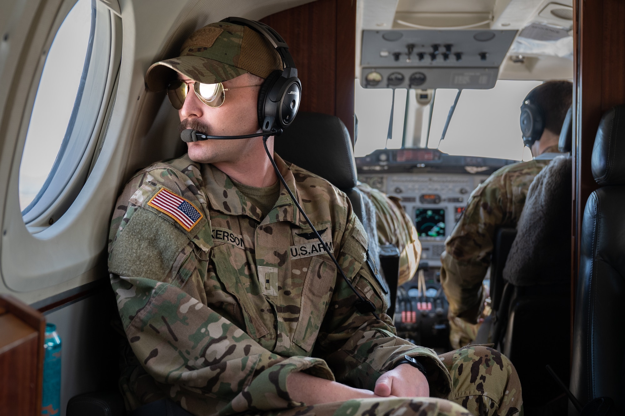 U.S. Army Warrant Officer Corey Ackerson, E-52 Aviation Regiment pilot, looks out the window of a C-12 Huron at Namji, Republic of Korea, March 13, 2024. The plane transported Airmen assigned to the 51st Fighter Wing to an emergency landing strip during routine agile combat employment training. ACE enhances the operational capabilities of the 51st FW and its allies by enabling rapid aircraft deployment from dispersed locations, ensuring adaptability and resilience in dynamic and contested environments. (U.S. Air Force photo by Senior Airman Brittany Russell)