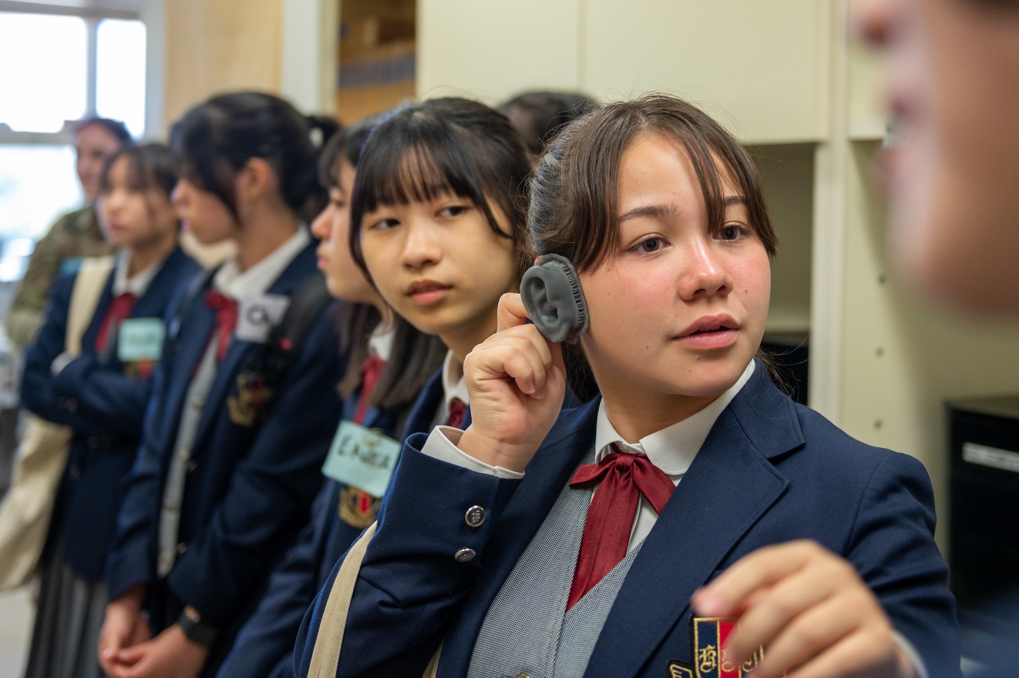 An Okinawan student holds up a 3D printed ear