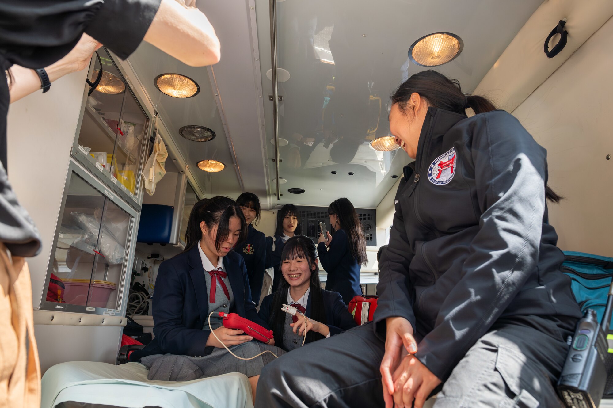 U.S. Air Force Staff Sgt. Jamie Ma, 18th Medical Group aerospace medical technician, shows Okinawan students the inside of an ambulance