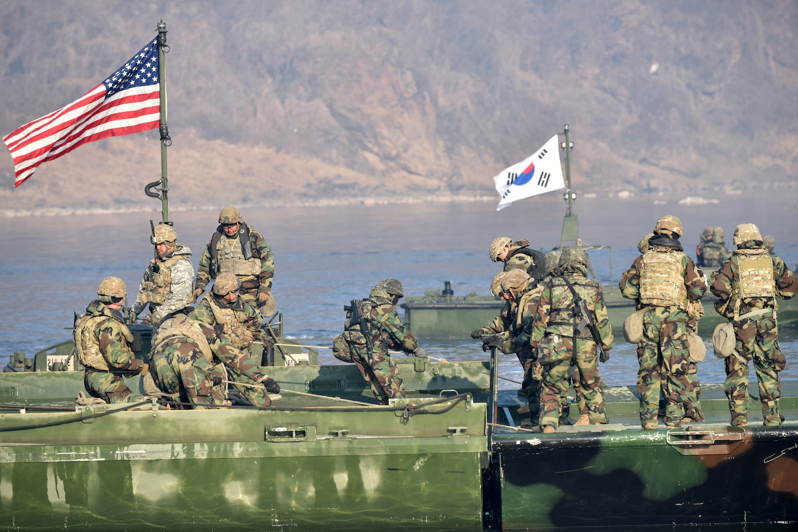 ROK Soldiers assigned to the 5th Corps Engineering Brigade River Crossing Company and Soldiers assigned to the 11th Engineer Battalion, 2nd Infantry Division Sustainment Brigade, 2nd Infantry Division ROK/U.S. Combined Division, complete construction on a joint bridge, during a combined wet gap crossing exercise, near the Imjin River in Paju-si, Gyeonggi-do from March 11-20, 2024. ROK and U.S. Army units utilized aviation, armor, air defense, chemical, biological and defense capabilities to train the security and protection of the site during the exercise that was designed to verify interoperability through the construction of a joint pontoon bridge. (U.S. Army photo by Pak, Chin-U)