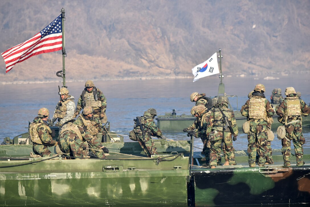 ROK Soldiers assigned to the 5th Corps Engineering Brigade River Crossing Company and Soldiers assigned to the 11th Engineer Battalion, 2nd Infantry Division Sustainment Brigade, 2nd Infantry Division ROK/U.S. Combined Division, complete construction on a joint bridge, during a combined wet gap crossing exercise, near the Imjin River in Paju-si, Gyeonggi-do from March 11-20, 2024. ROK and U.S. Army units utilized aviation, armor, air defense, chemical, biological and defense capabilities to train the security and protection of the site during the exercise that was designed to verify interoperability through the construction of a joint pontoon bridge. (U.S. Army photo by Pak, Chin-U)
