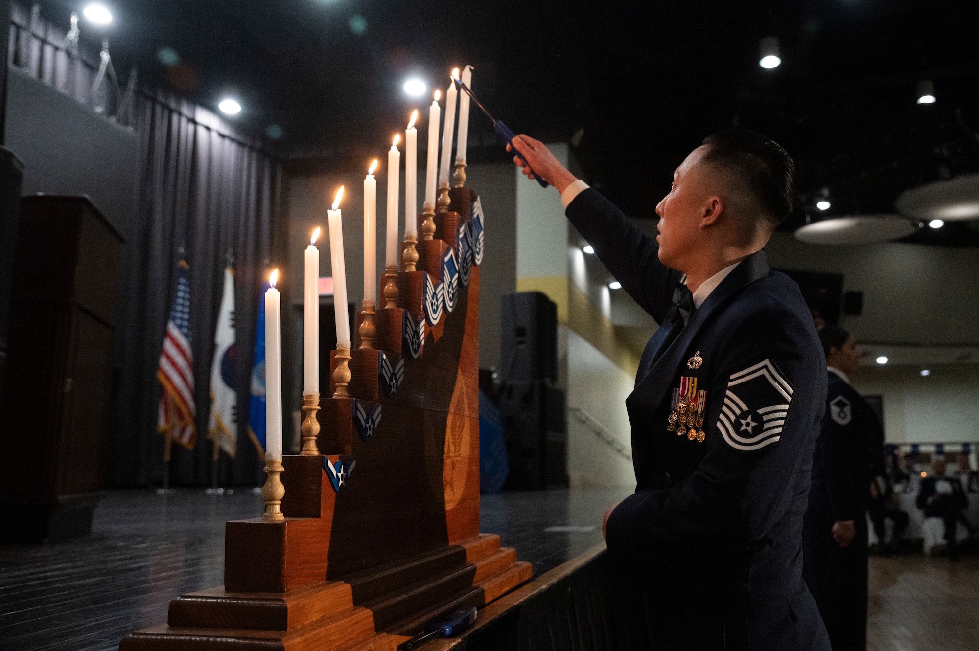 U.S. Air Force Senior Master Sgt. Kevin Hong, 51st Logistics Readiness Squadron deployment and distributions flight superintendent, lights a candle during the 51st Fighter Wing Chief Recognition Ceremony at Osan Air Base, Republic of Korea, March 15, 2024.