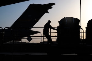 An Airman pushes a pallet of humanitarian aid destined for Gaza onto a C-17.