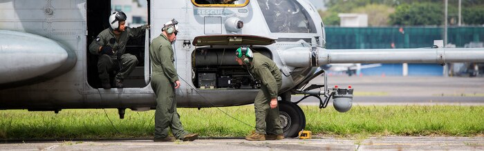 U.S. Marines with the Aviation Combat Element, Special Purpose Marine Air-Ground Task Force - Southern Command, check over their CH-53E Super Stallion helicopter before departing  La Aurora International Airport in Guatemala City, Guatemala, Aug. 1, 2017.