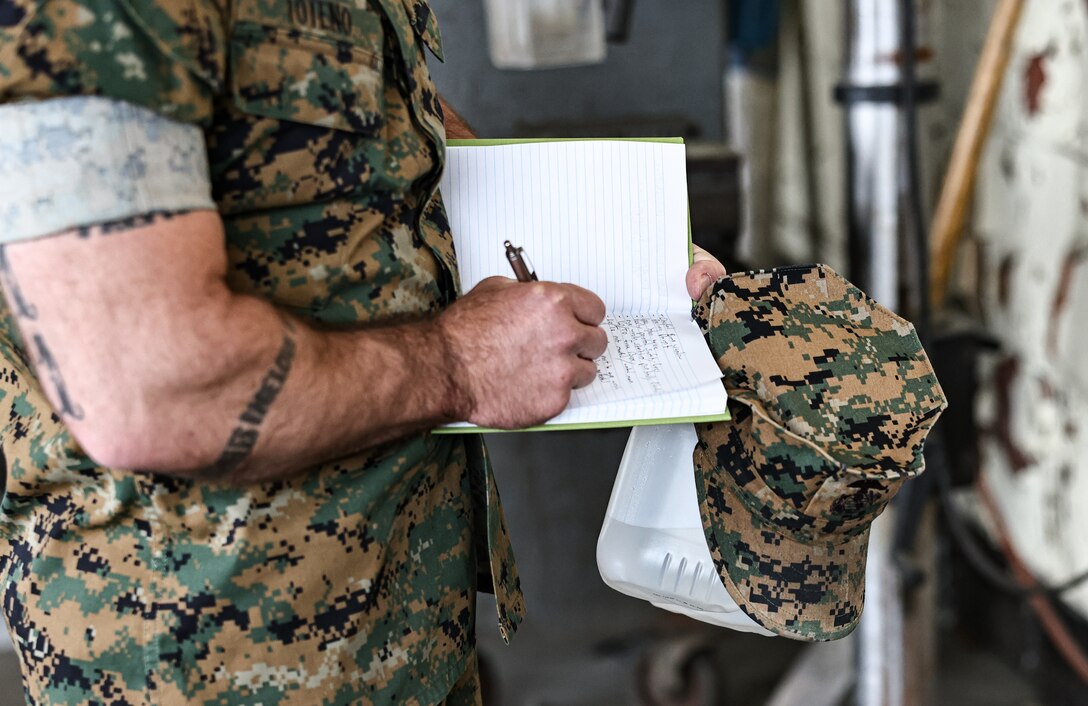 U.S. Marine Corps Gunnery Sgt. Jeremy J. Toteno, battery gunnery sergeant with Golf Battery, 3rd Battalion, 14th Marine Regiment, writes down notes during a mock inspection of hazard identification in the Ground Safety for Marines (GSM) Course on Marine Corps Base Camp Lejeune, North Carolina, April 24, 2023. GSM is a course for Marines and Sailors that provided occupational safety and health training to military and Department of Defense civilian personnel assigned to duties regarding ground safety. (U.S. Marine Corps photo by Lance Cpl. Loriann Dauscher)