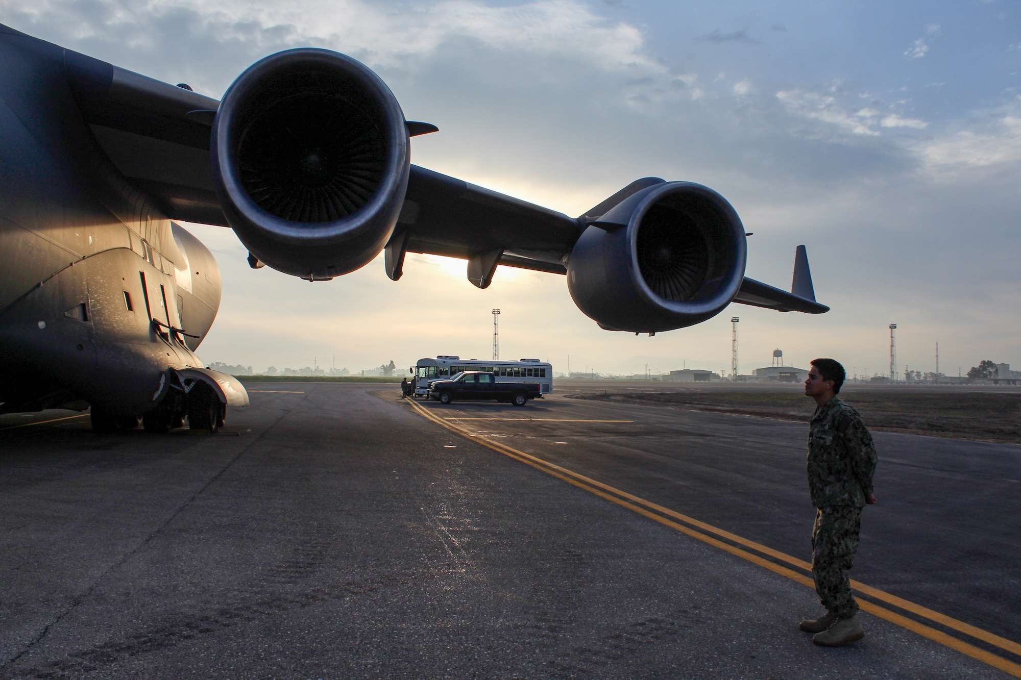 A U.S. Navy service member looks on at a C-17 Globemaster III during Exercise Rising Phoenix, Feb. 6, 2024, at Morón Air Base, Spain.