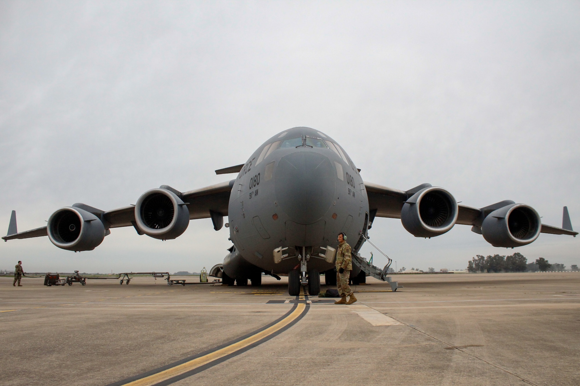 A U.S. Air Force service member walks in front of a C-17 Globemaster III while it gets refueled during Exercise Rising Phoenix, Feb. 8, 2024, at Morón Air Base, Spain.