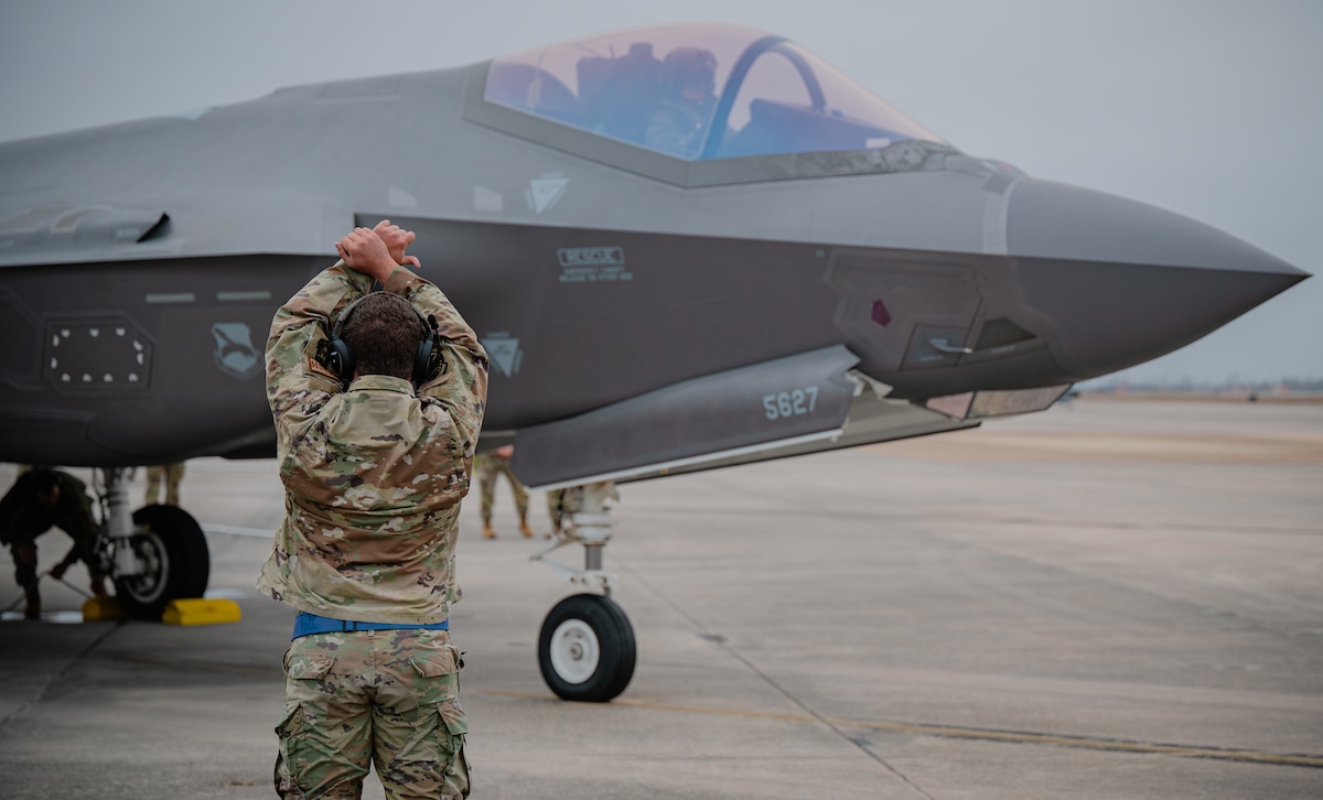 Airman signals to pilot