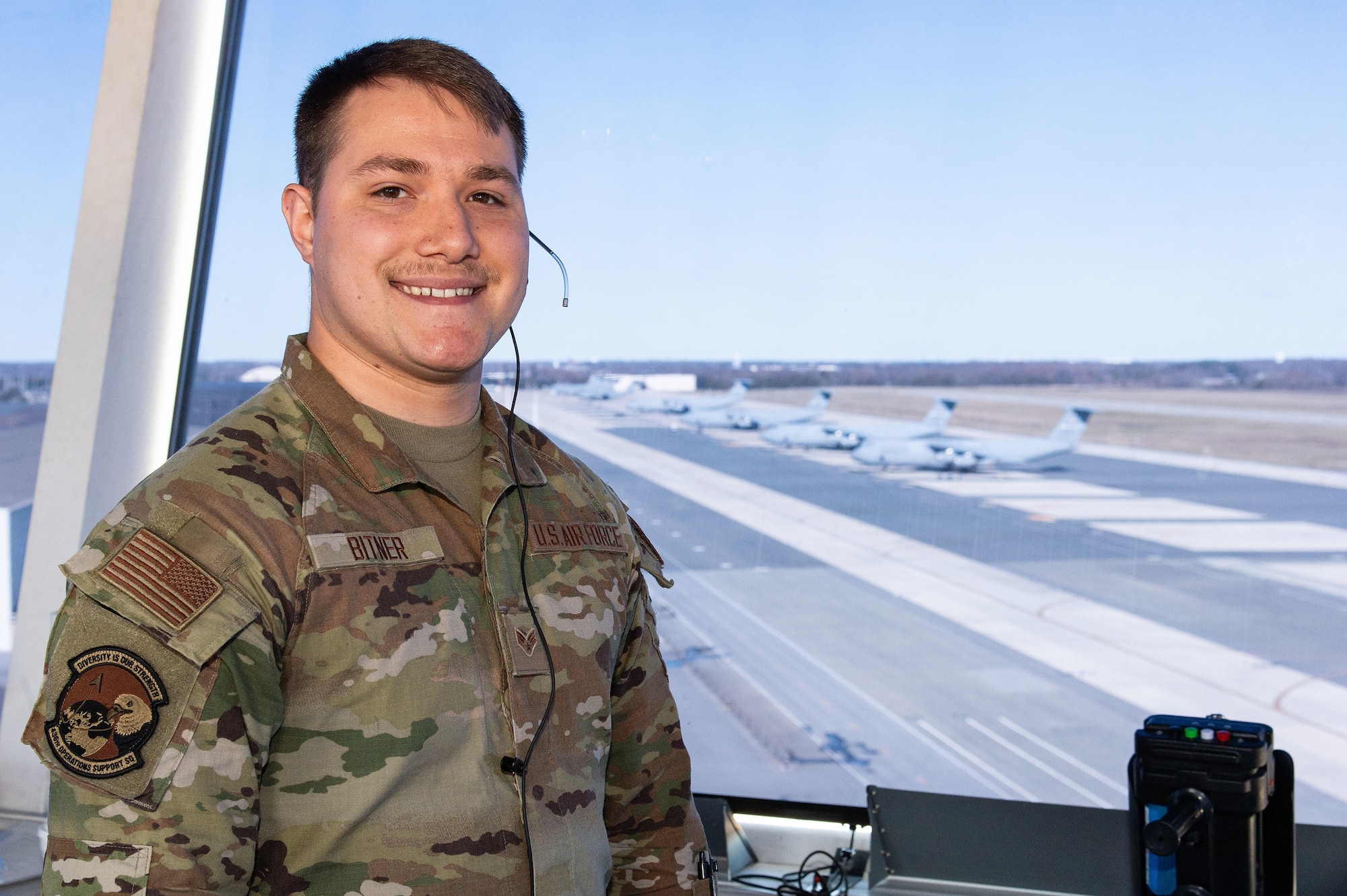 U.S. Air Force Senior Airman Cohen Bitner, 436th Operations Support Squadron air traffic control trainer, stands in the cab of the control tower at Dover Air Force Base, Delaware, March 11, 2024. Bitner was recognized as the 2023 Air Mobility Command Outstanding Air Traffic Control Airman of the Year. (U.S. Air Force photo by Roland Balik)