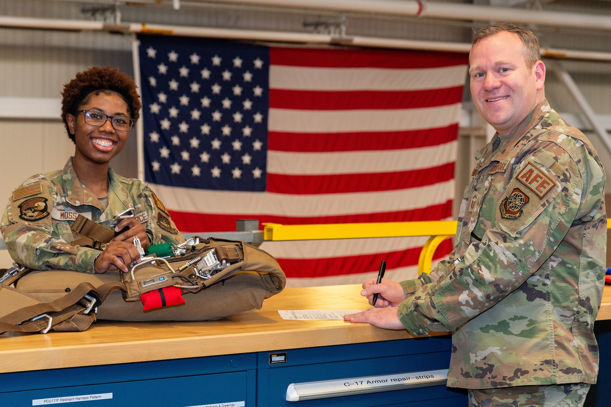 U.S. Air Force Airman 1st Class Faith Moss, left, 436th Operations Support Squadron aircrew flight equipment journeyman, and U.S. Air Force Senior Master Sgt. Christopher Smith, 436th OSS AFE superintendent, inspect a parachute at Dover Air Force Base, Delaware, March 12, 2024. Moss was recognized as the 2023 Air Mobility Command Outstanding AFE Airman of the Year, and Smith was the 2023 AMC Outstanding AFE Senior Noncommissioned Officer of the Year. (U.S. Air Force photo by Roland Balik)