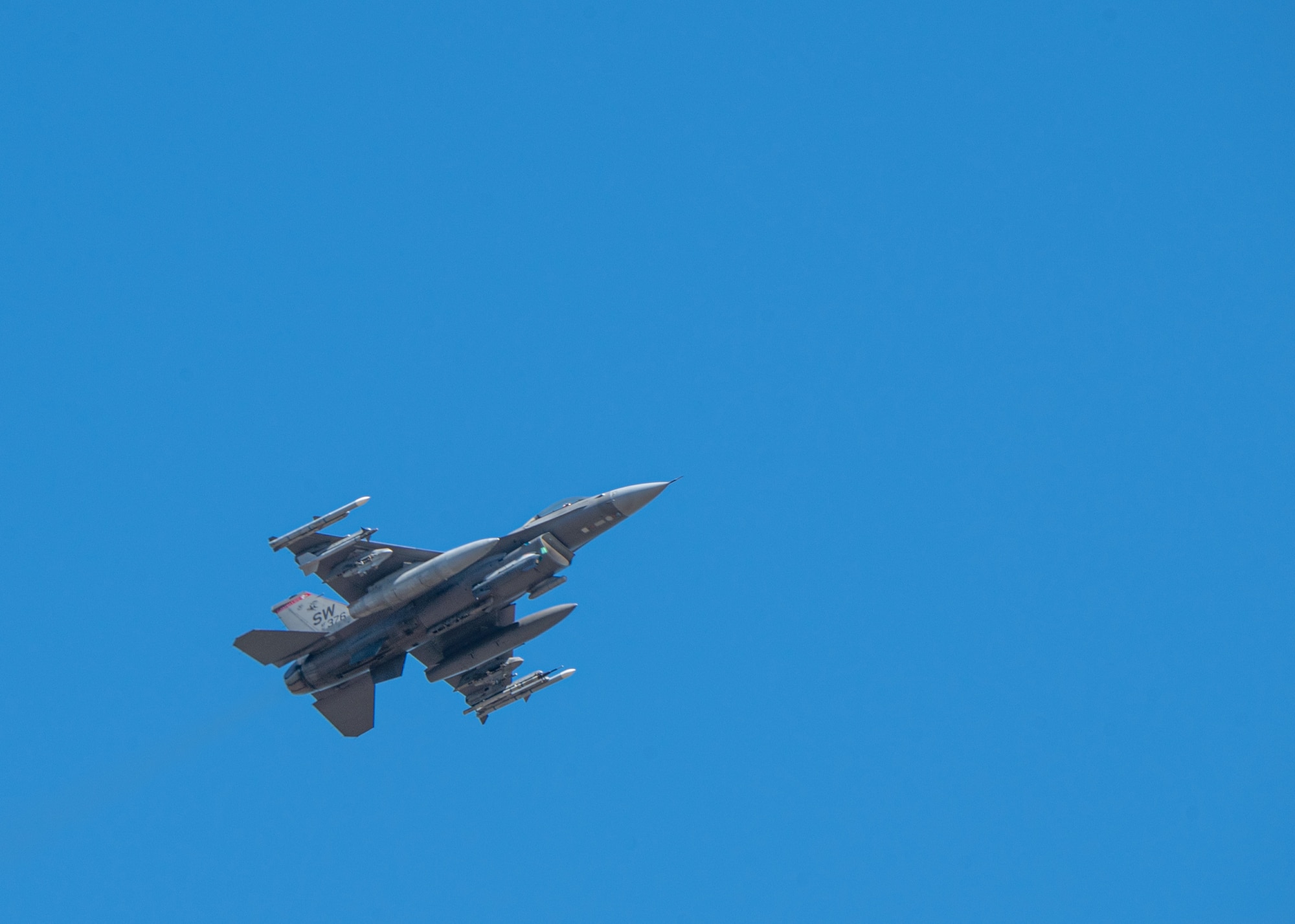 An underneath view of a jet ascending in the sky.