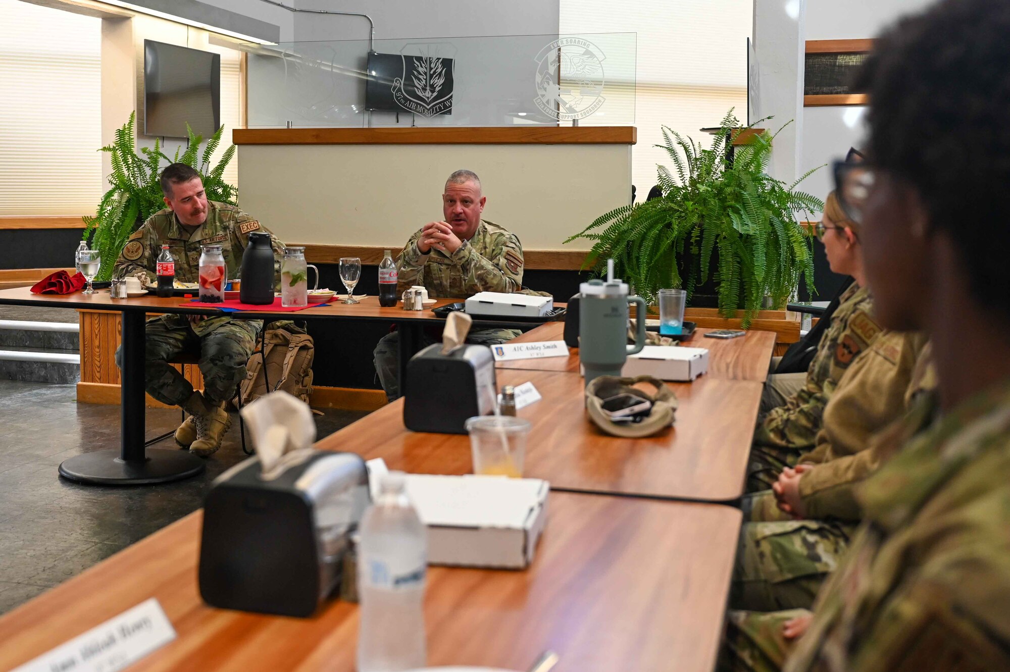 U.S. Air Force Chief Master Sgt. Justin Apticar, 19th Air Force command chief, eats lunch with Airmen from the 97th Air Mobility Wing at Hangar 97, March 12, 2024.Apticar asked each Airmen to tell him about themselves before explaining what they can expect when the Air Education and Training Command changes to Airmen Development Command on March 22, 2024. (U.S Air Force photo by Airman 1st Class Kari Degraffenreed)