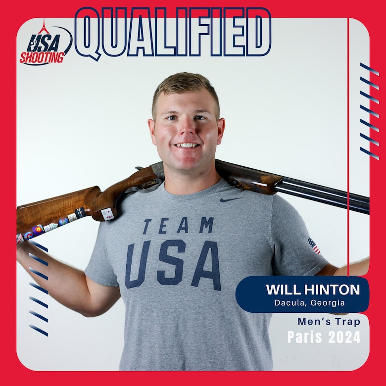 Man in Team USA shirt standing with shotgun.