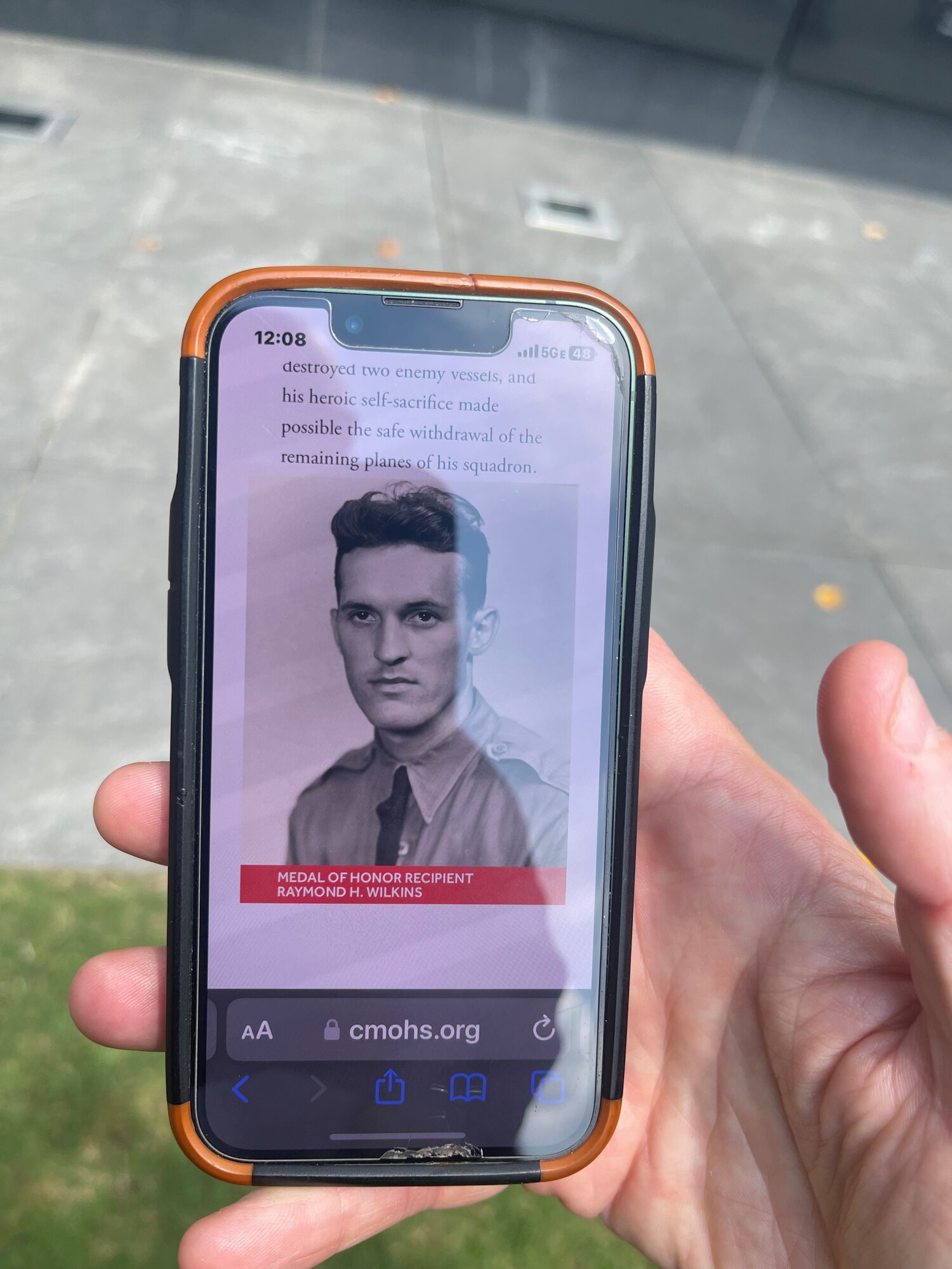 Kerry Wilkins shows a photo of her great uncle, Maj. Raymond H. Wilkins, on her phone while visiting the Air Force Memorial’s Medal of Honor Wall in Arlington, Va., July 2023.
