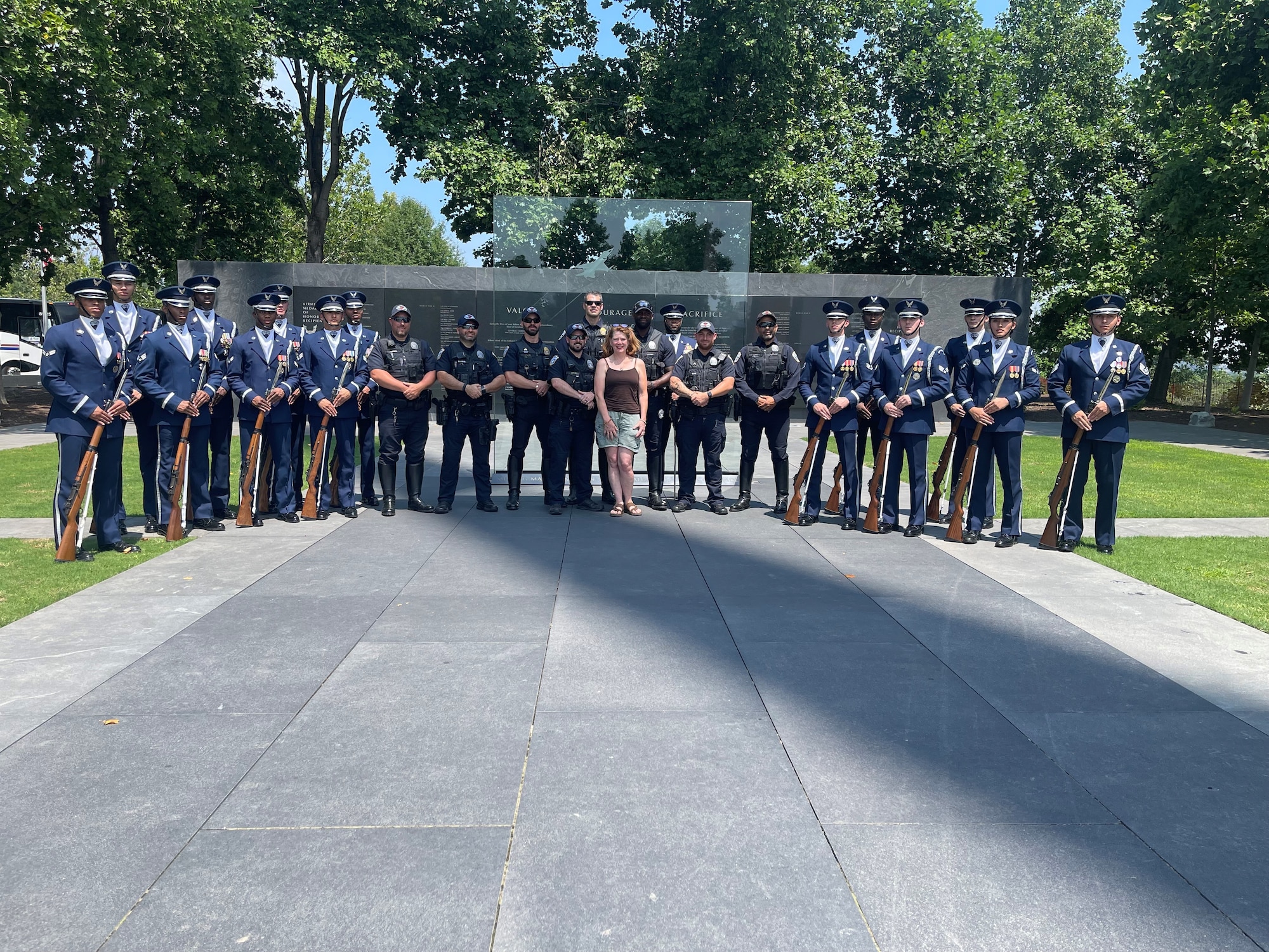 Kerry Wilkins poses for a photo with members of the Air Force Honor Guard and National Park Police in front of the Air Force Memorial’s Medal of Honor Wall in Arlington, Va., July 2023.