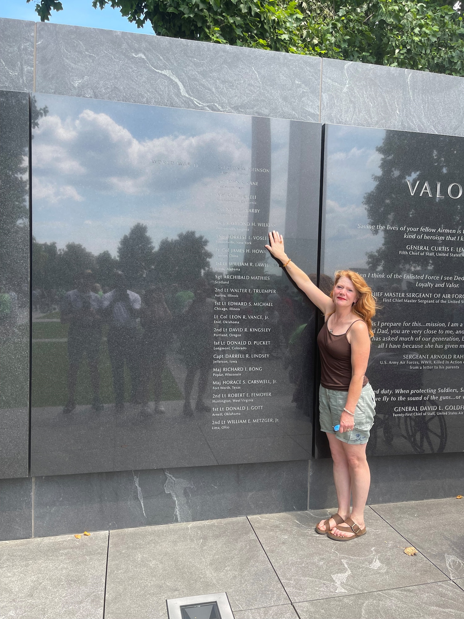Kerry Wilkins places her hand on the name of her great uncle, Maj. Raymond H. Wilkins, while visiting the Air Force Memorial’s Medal of Honor Wall in Arlington, Va., July 2023.