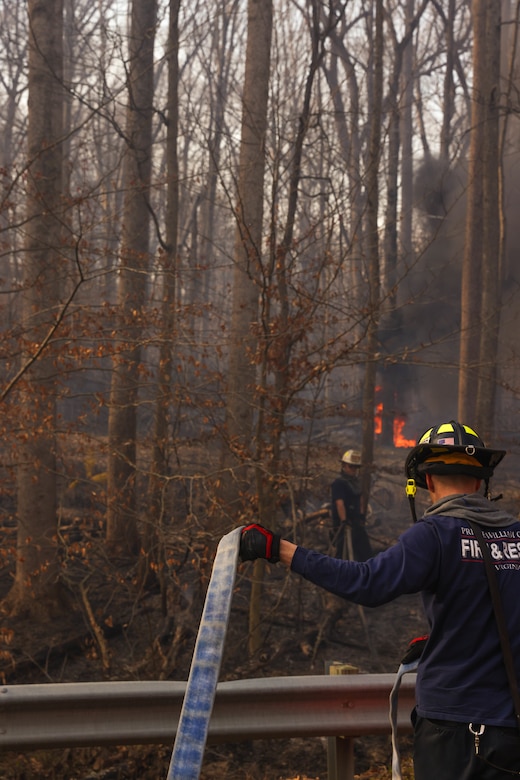 Firefighters and other first responders with Prince William County work to put out a large bush-fire along Richmond Highway, Triangle, Virginia, March 20, 2024. First Responders surround and close off all surrounding area of the fire to ensure proper safety of both civilians and first-responders. (U.S. Marine Corps photo by LCpl. Isabelle Hutmacher)