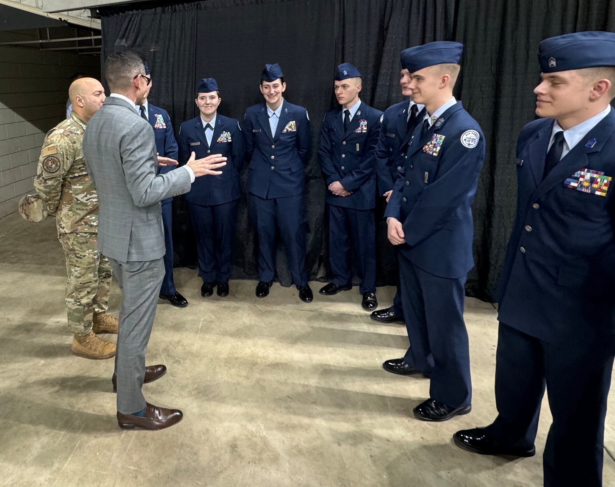 The Honorable Alex Wagner presents a coin to an Air Force Junior ROTC cadet during the Open Drill Nationals competition.