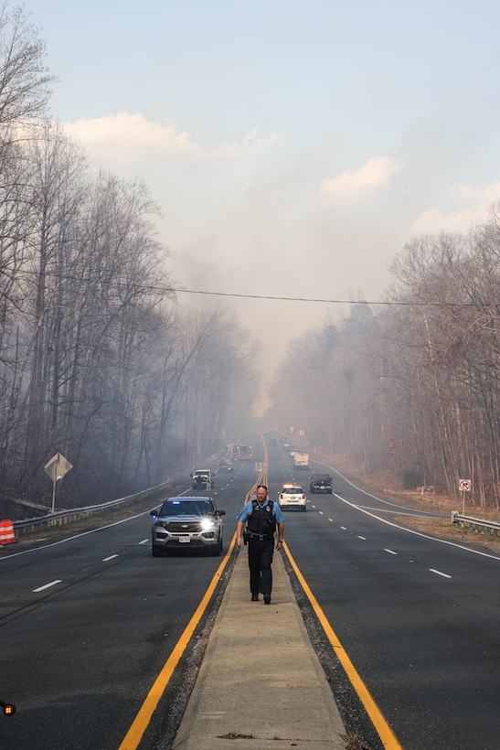 Firefighters and other first responders with Prince William County work to put out a large bush-fire along Richmond Highway, Triangle, Virginia, March 20, 2024. First Responders surround and close off all surrounding area of the fire to ensure proper safety of both civilians and first-responders. (U.S. Marine Corps photo by LCpl. Isabelle Hutmacher)
