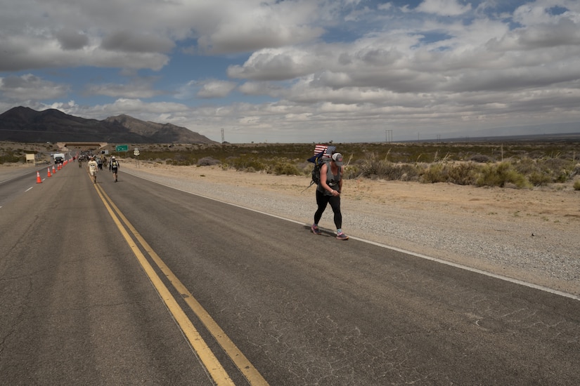 A woman walks on a long road.