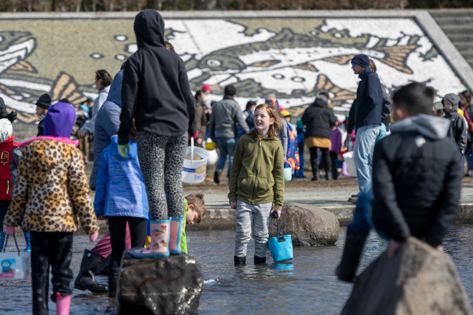 Young participants play near the Oirase River shortly before the start of the 25th annual Oirase Salmon Release at Shimoda Salmon Park, Japan, March 16, 2024.