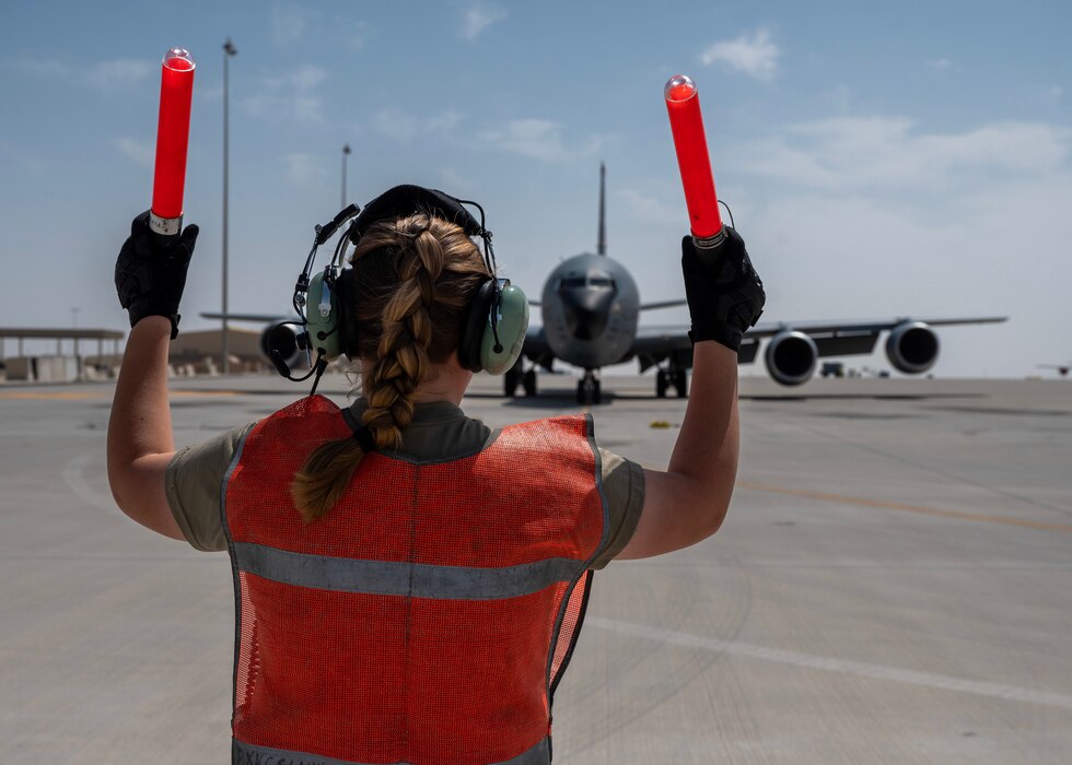 A U.S. Air Force crew chief marshals a KC-135 Stratotanker at an undisclosed location in the U.S. Central Command area of responsibility, Mar. 21, 2024. Crew chiefs utilize hand signals and marshalling techniques to guide aircraft safely on the ground during taxiing and parking operations. (U.S. Air Force photo)